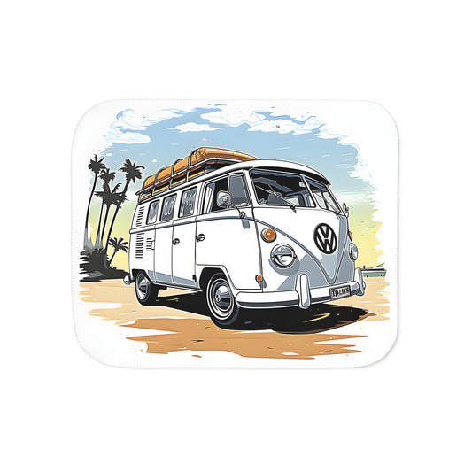 Colorful blanket featuring a vintage-inspired Volkswagen van design with surfboards on the roof, parked on a sunny beach surrounded by palm trees and a bright blue sky.