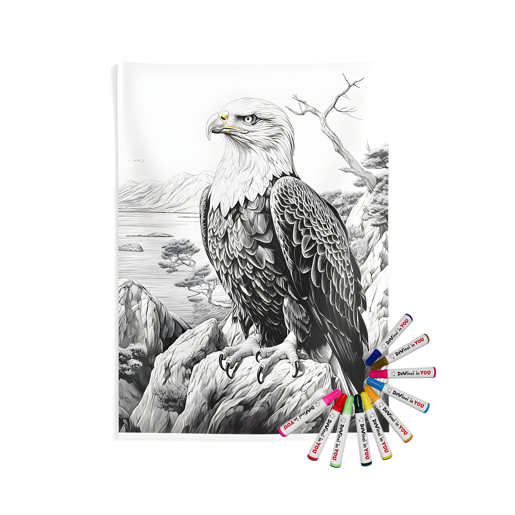 A detailed illustration of an American eagle perched on a rocky cliffside with mountains and trees in the background, printed on an indoor wall tapestry, perfect for home decor. Includes 10 fabric markers for coloring.