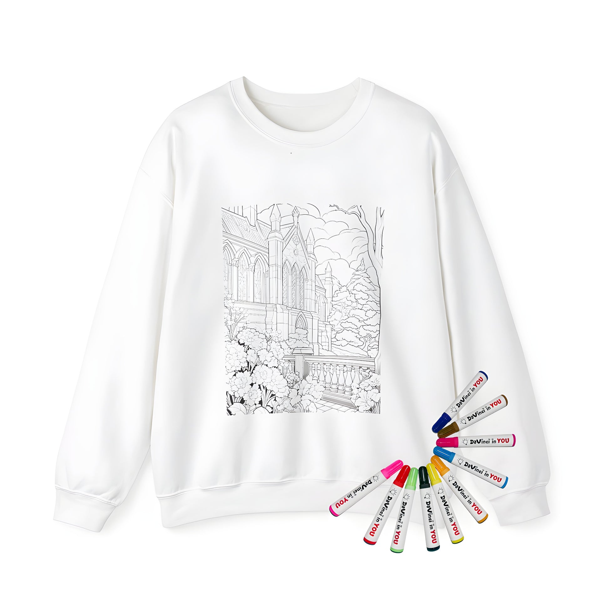 Adult sweatshirt featuring a detailed illustration of a medieval church, castle, or cathedral design surrounded by flowers, trees, and a cloudy sky. Part of an adult coloring kit with fabric markers.