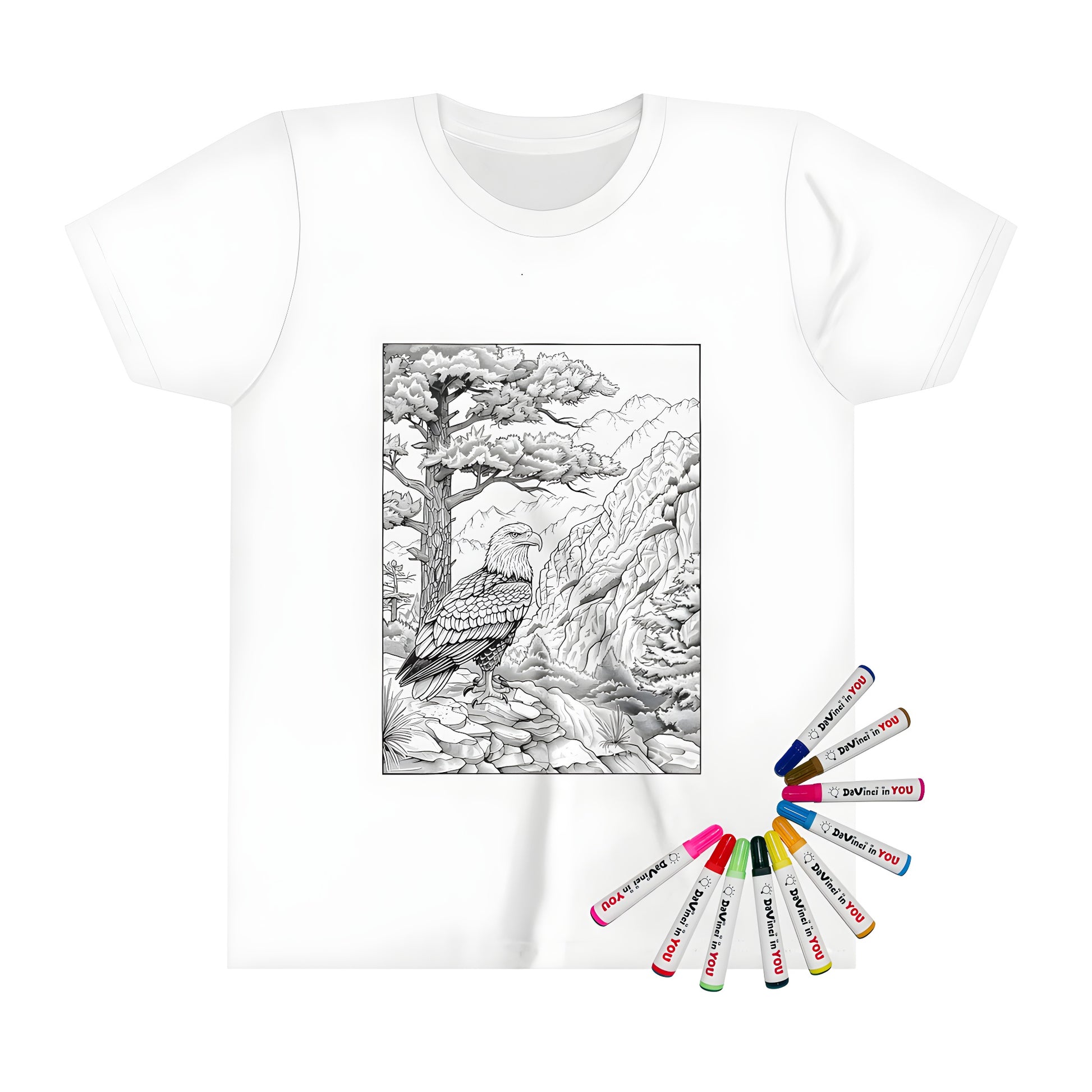 Coloring book page print on kid's t-shirt with eagle perched on rock, mountainous forest scenery and trees in background.