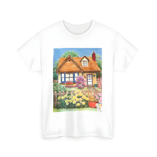 A colorful unisex t-shirt featuring a charming village scene of a cottage surrounded by a vibrant garden with flowers, bushes, and a picket fence under a blue sky.