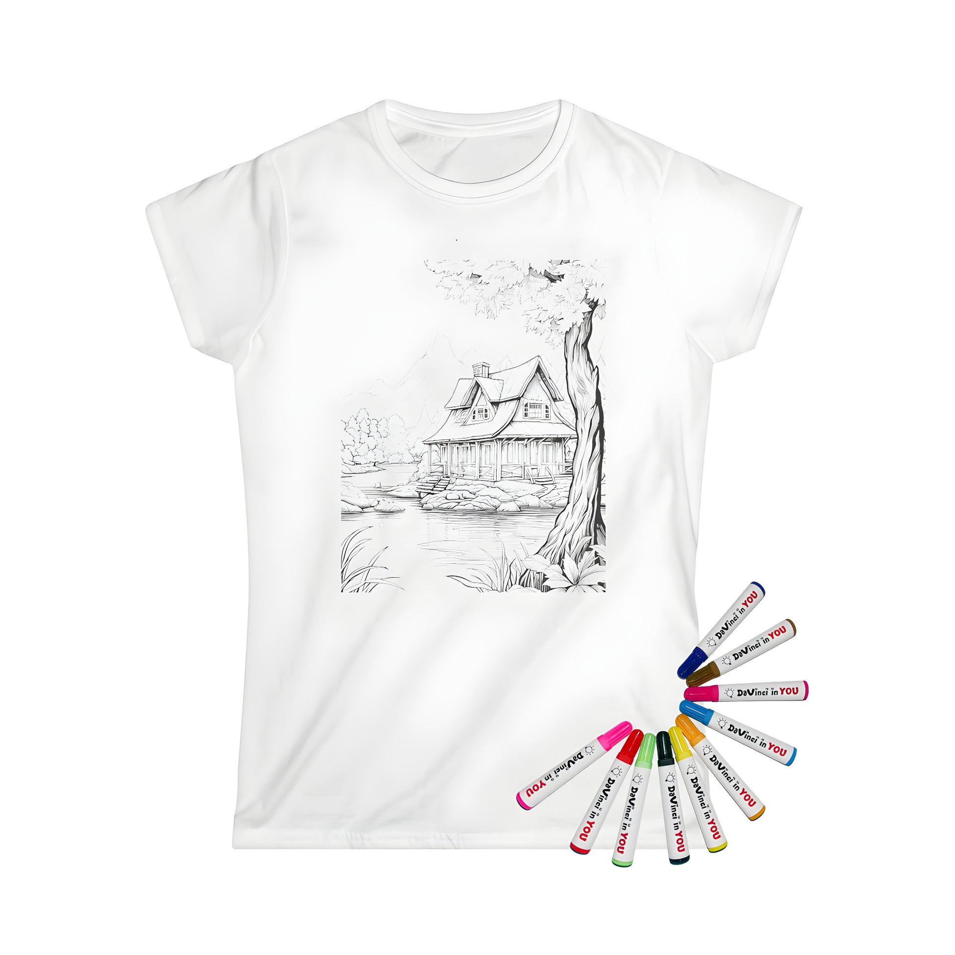 Woman wearing a black and white cabin illustration t-shirt with lake scenery, trees, and mountains in the background