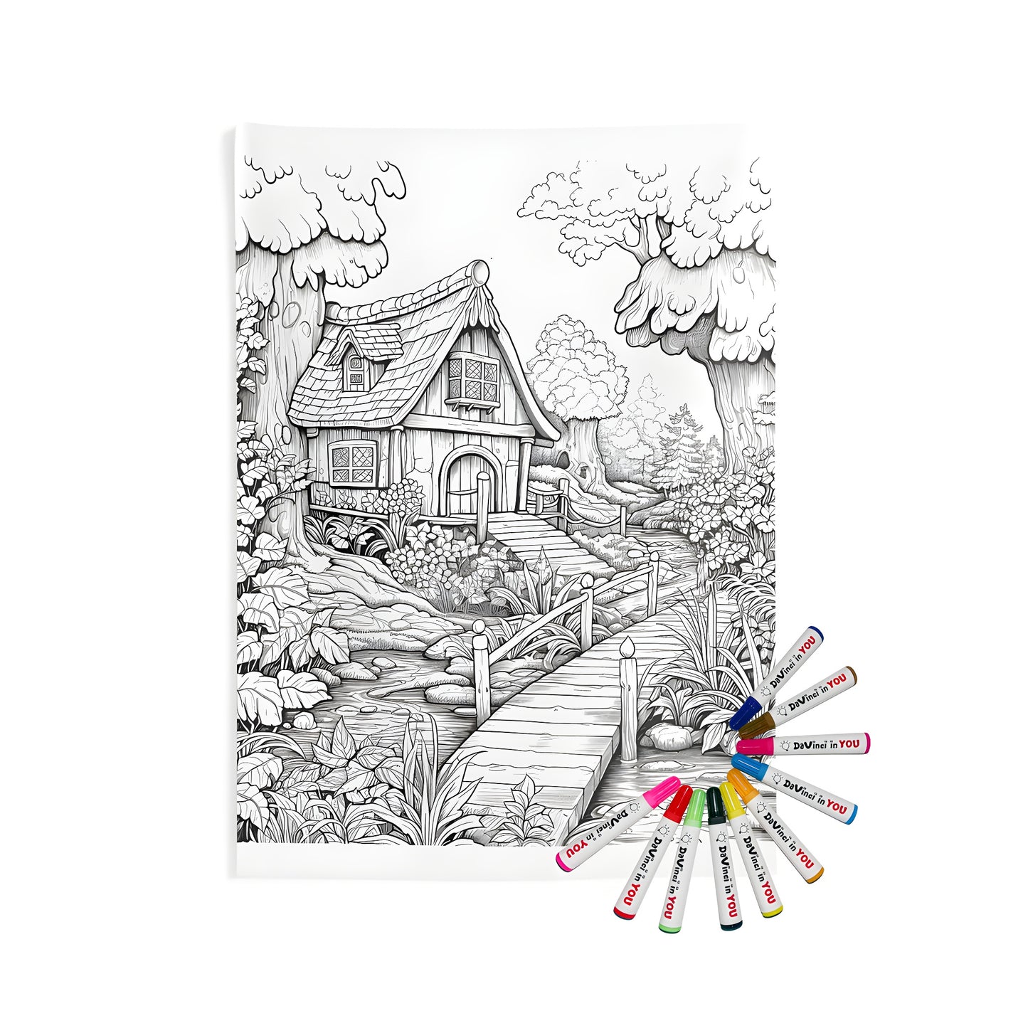 A detailed black and white illustration of an enchanted cottage nestled in a whimsical forest with a serene stream and wooden bridge, printed on a vibrant indoor wall tapestry. Includes 10 fabric markers for creative coloring.