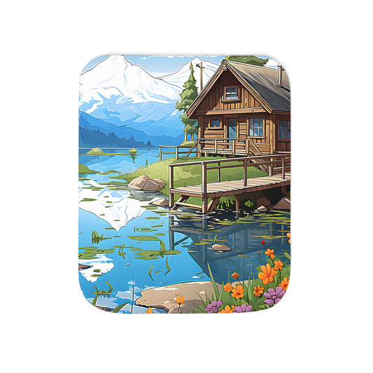 Cozy blanket featuring a serene wooden cabin scene by a peaceful lake with mountain reflection and lush greenery