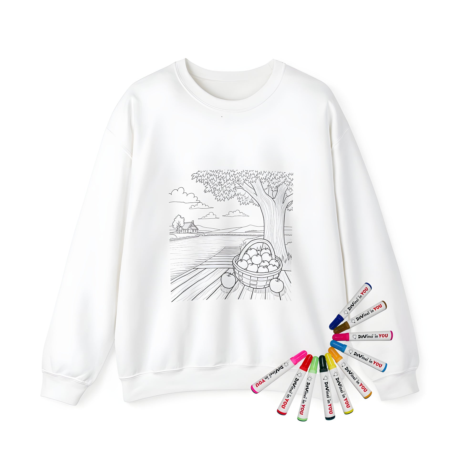 Adult sweatshirt featuring a peaceful countryside scene of a basket of apples on a wooden dock beside a tree, overlooking a serene river and distant cottage