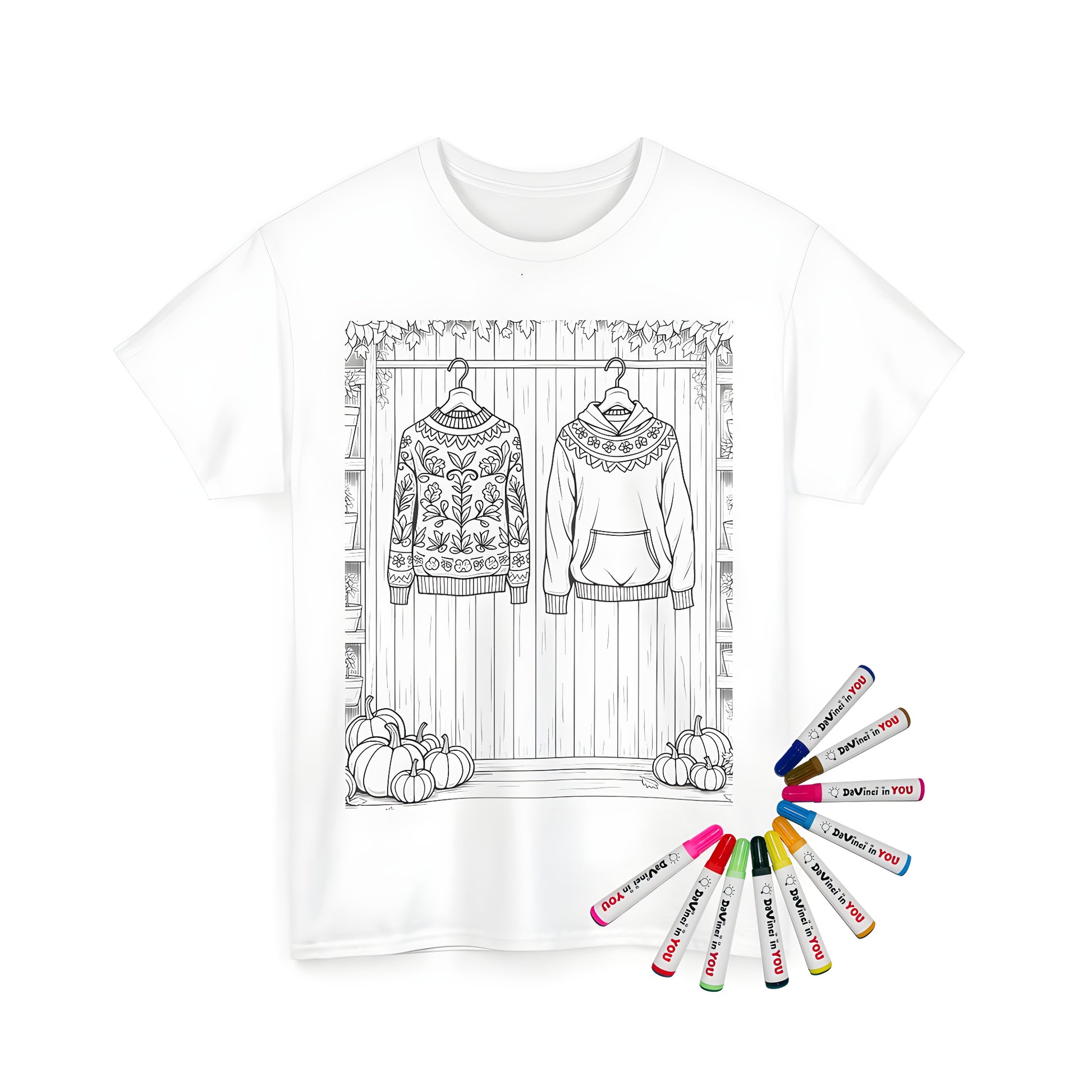 A stylish sweater-inspired coloring page printed on a unisex t-shirt with decorative patterns surrounded by pumpkins and potted plants against a wooden wall. Includes fabric markers.